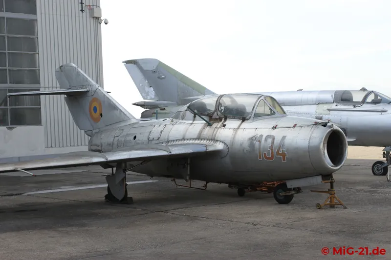 The way to the military maintenance hangar leads past stored aircraft, including a MiG-15UTI ...