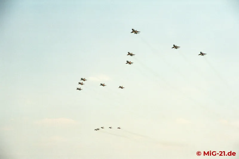... three five-ship formations of MiG-21bis and UM fly over the airfield.